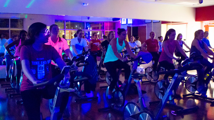 NC State students taking a glow cycle class