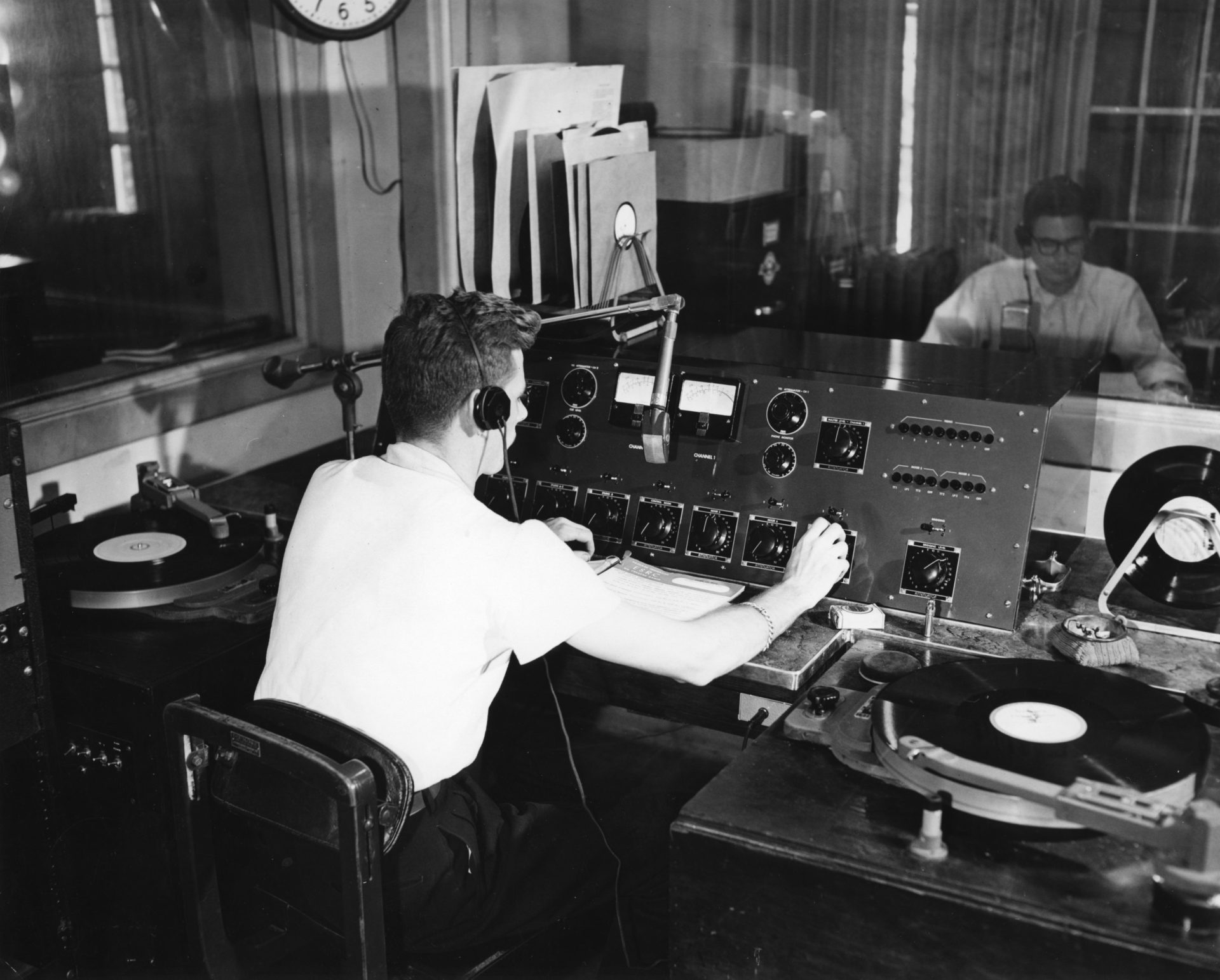 black and white photograph of a radio DJ in a studio in 1952