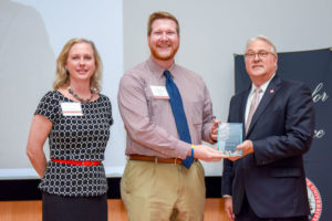 Brian Mathis receives Award of Excellence from Chancellor Randy Woodson and Senior Associate Vice Chancellor in the Division of Academic and Student Affairs Lisa Zapata