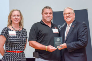 Travis Sills receives Award of Excellence from Chancellor Randy Woodson and Senior Associate Vice Chancellor in the Division of Academic and Student Affairs Lisa Zapata