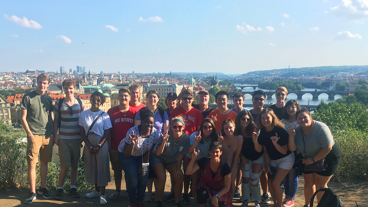 A group of students in the Global Leadership minor program stand together on top of a hill overlooking Prague