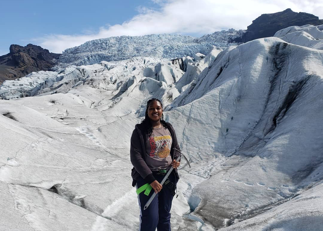 Safari Richardson stands in front of a glacier