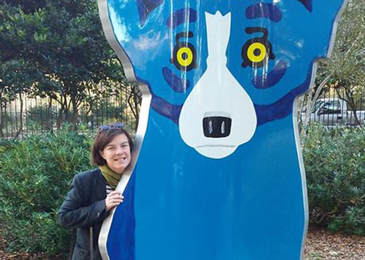 Holly Hurlburt stands next to an art installation featuring a cartoon dog