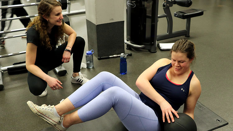 Whitney Knollenberg working with a student personal trainer.