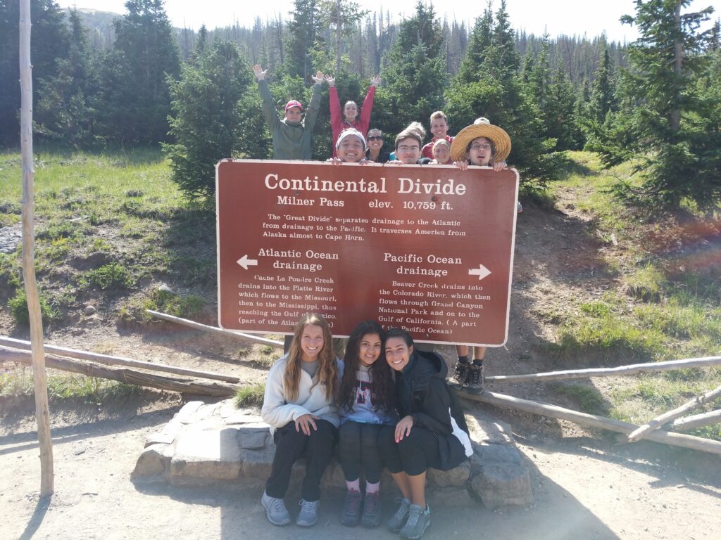 Group of students pose with the sign for the Continental Divide