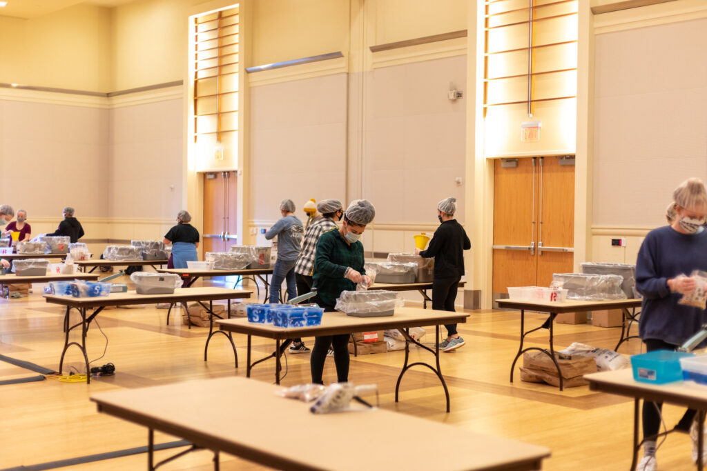 Masked students box meals at individual tables in the Talley Ballroom
