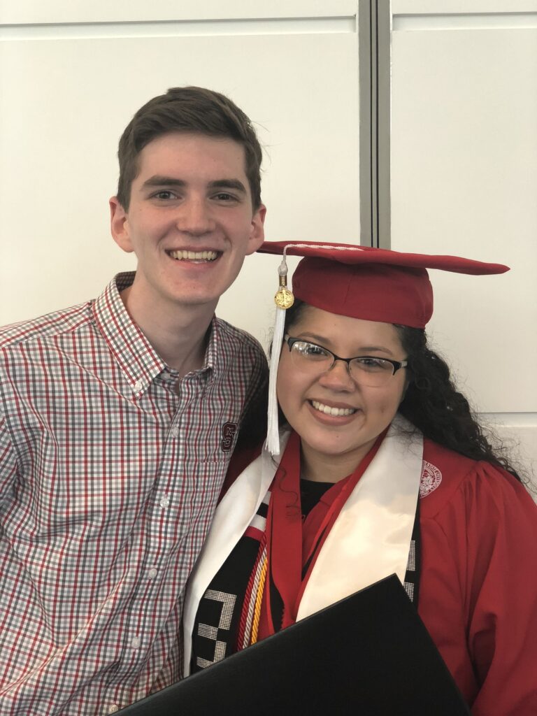 Moravec and Gonzalez, who is wearing a red NC State graduation cap and gown