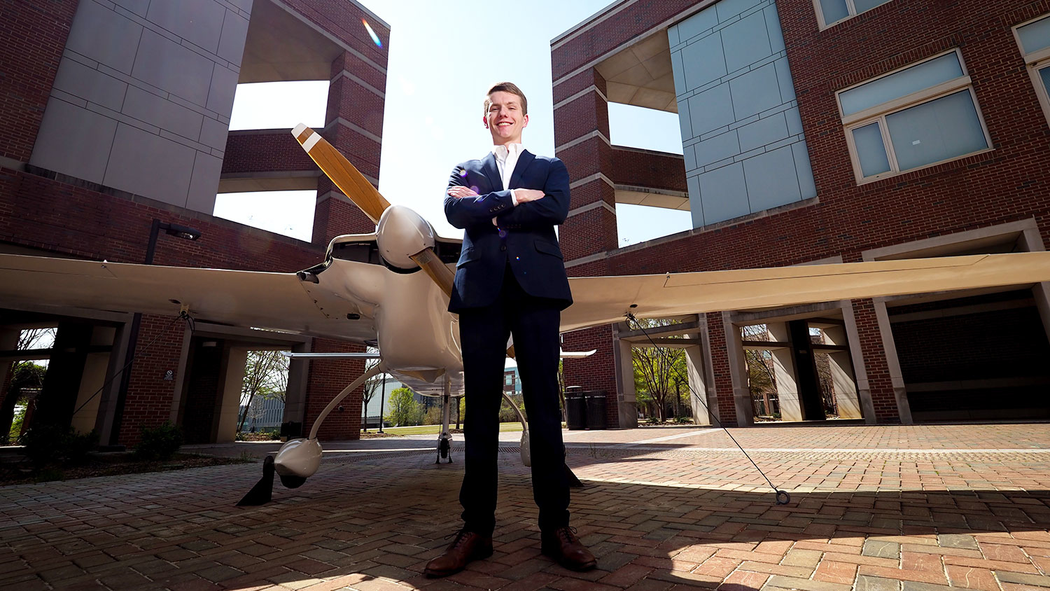 Goldwater Scholar Andrew Mistele in front of an airplane near the Engineering buildings on Centennial Campus