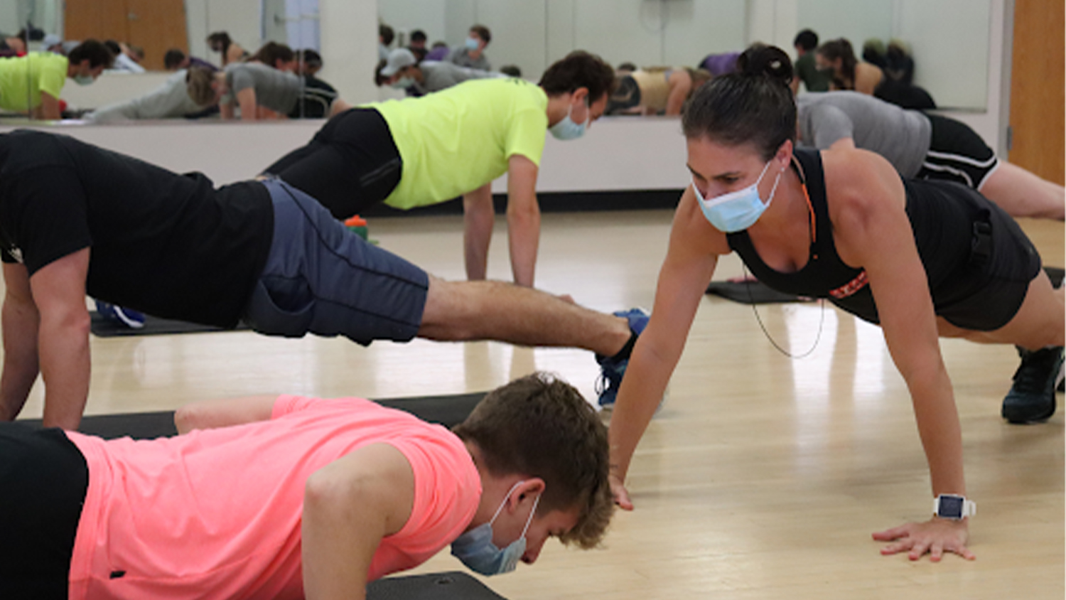 Renee Harrington and her students do pushups during class