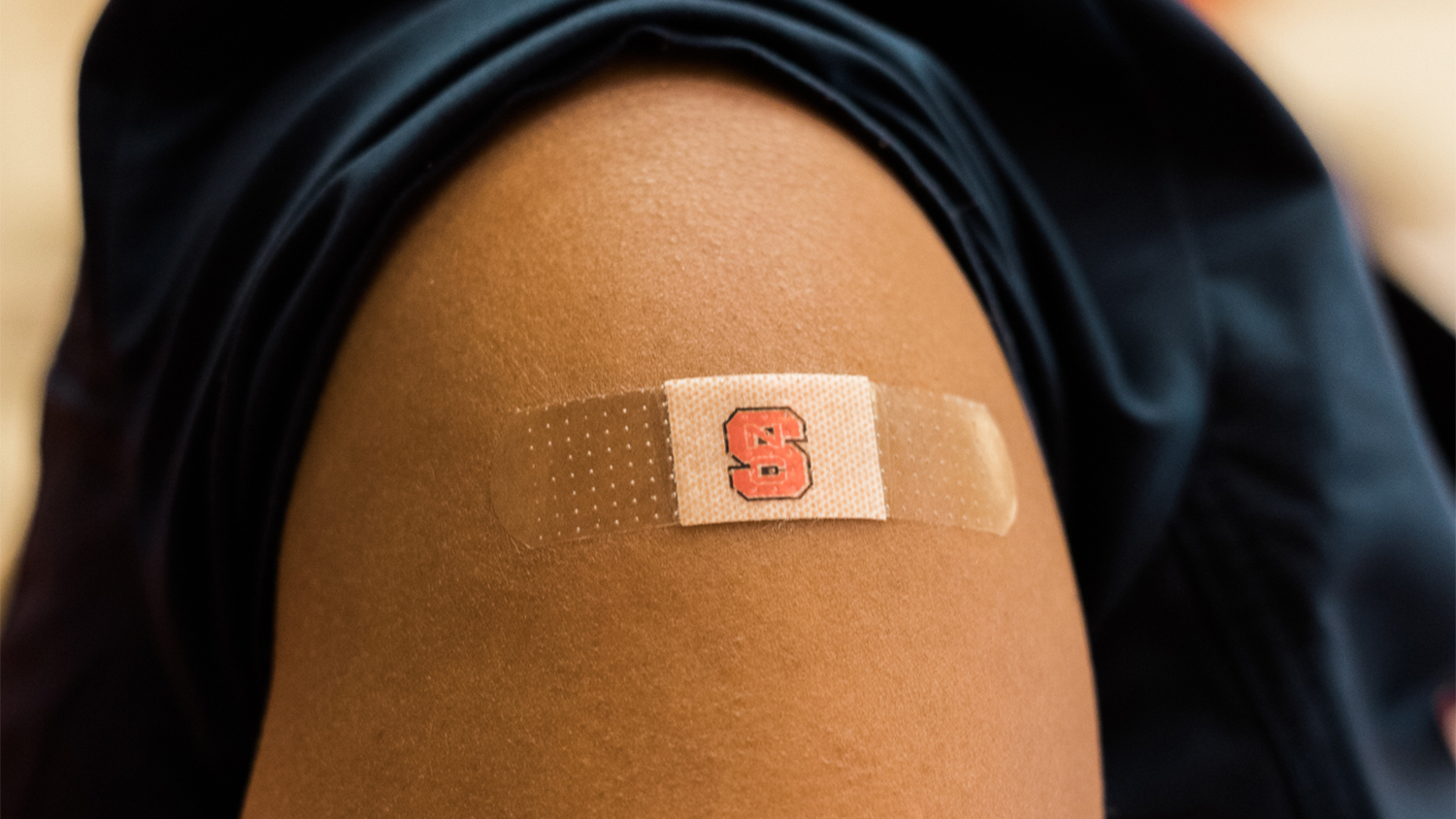 An NC State branded bandaid on a student's arm