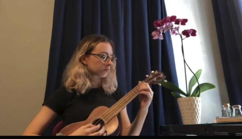 Adah Freeman playing the ukulele in her room