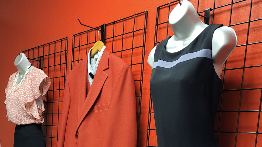 Professional clothing displayed on mannequins on a red wall