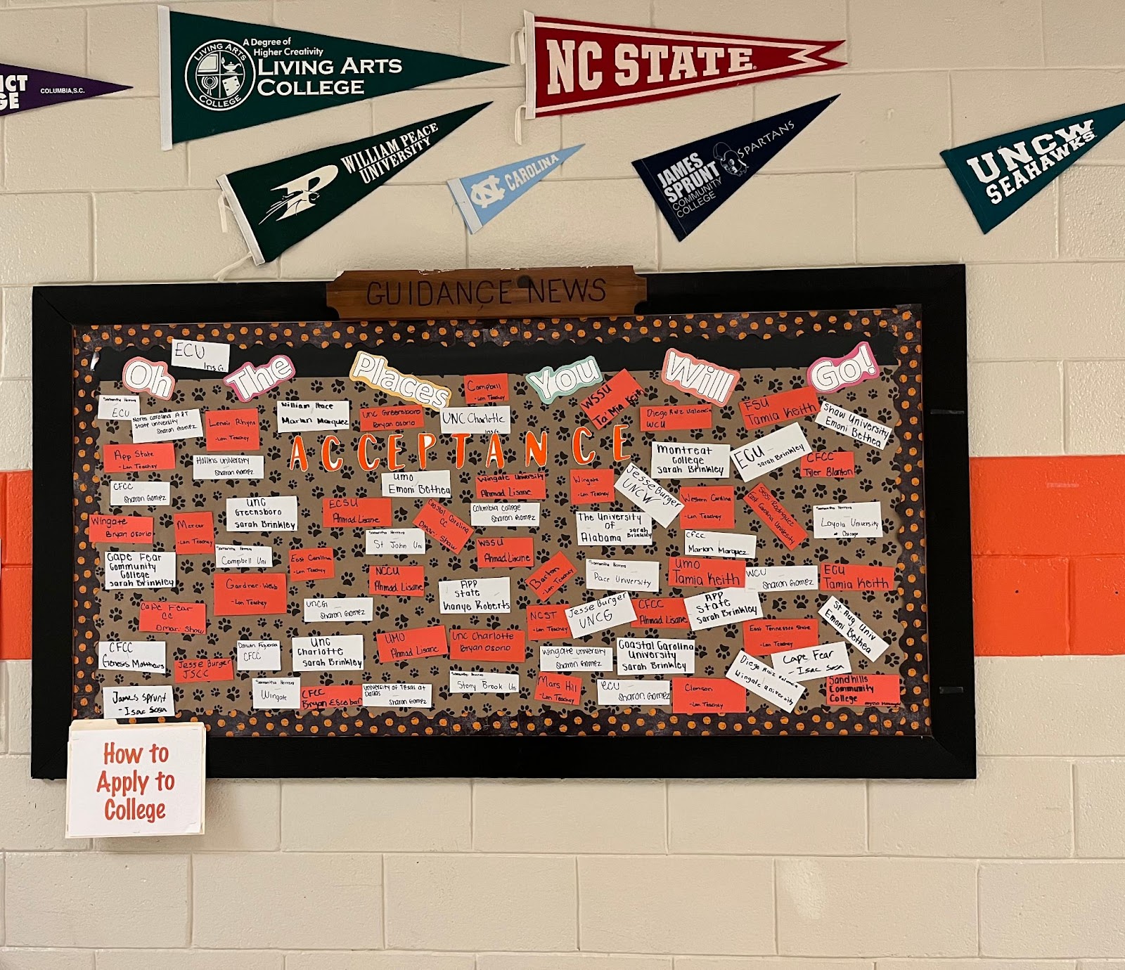 A bulletin board covered in pennants and other items from different colleges and universities
