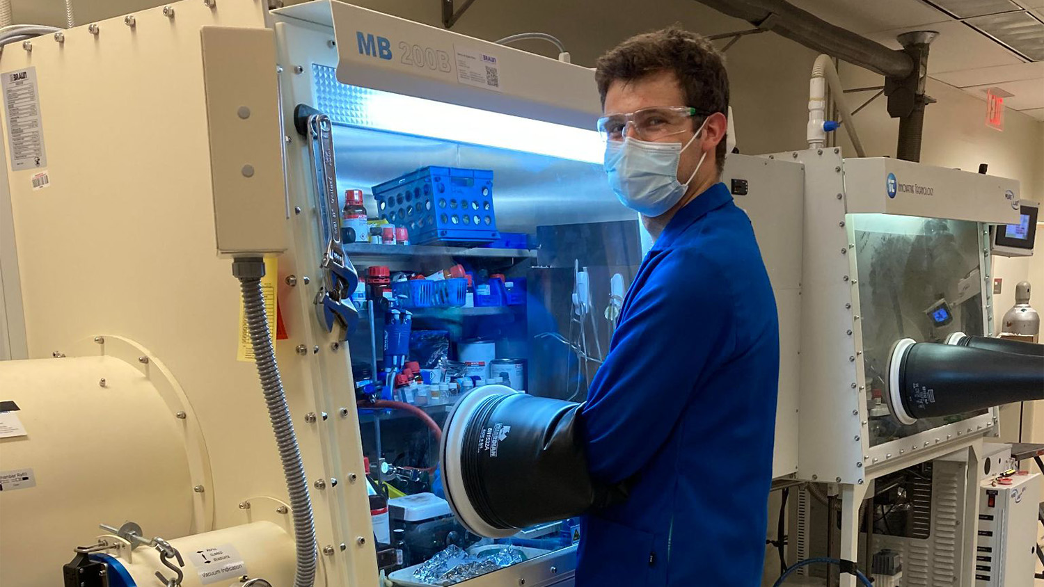 Ben Masters wearing a mask and gloves, working in the lab