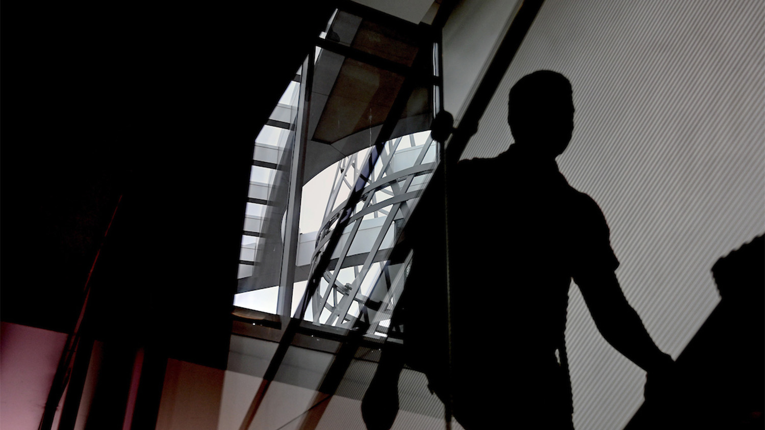 Silhouette of a student climbing stairs indoors, with the Technology Tower of Talley Student Union in the background
