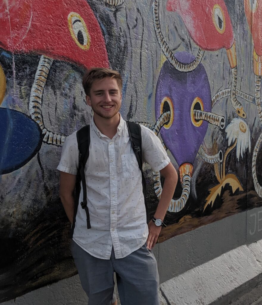 Sean Douglas in front of a mural painted wall
