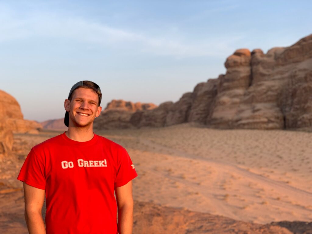 Zack wearing a "Go Greek" T-shirt while studying abroad in Wadi Rum in 2019