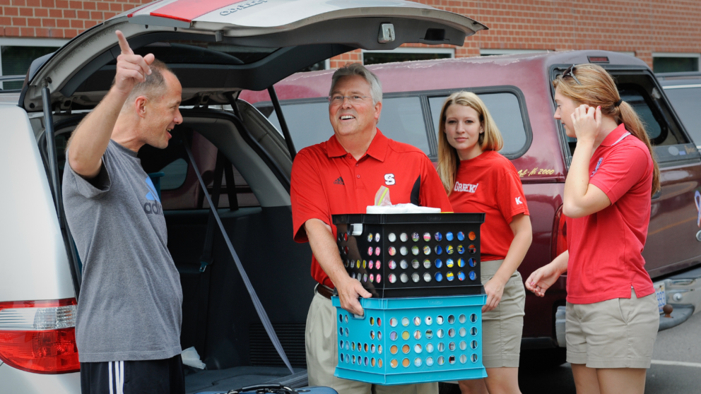 Chancellor Woodson carries baskets for a family moving in