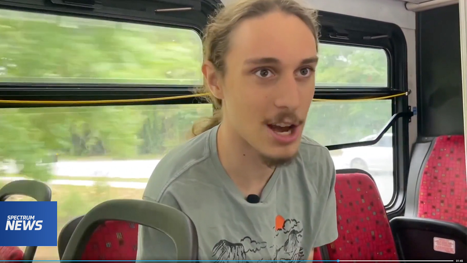 Etienne Phillips sitting inside a Wolf Line bus and speaking to the camera