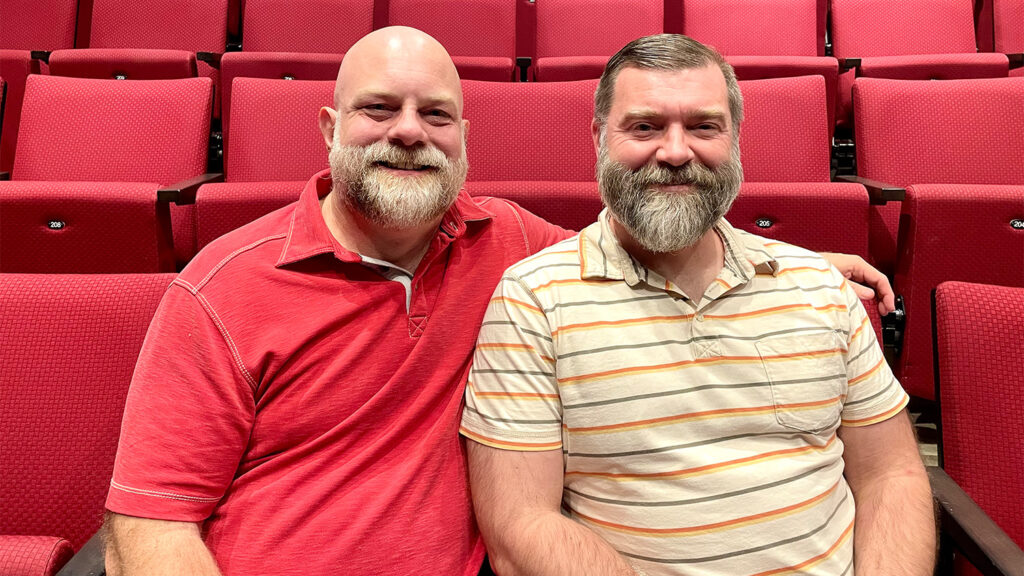 Christopher and Heath seated in the red chairs in Stewart Theatre