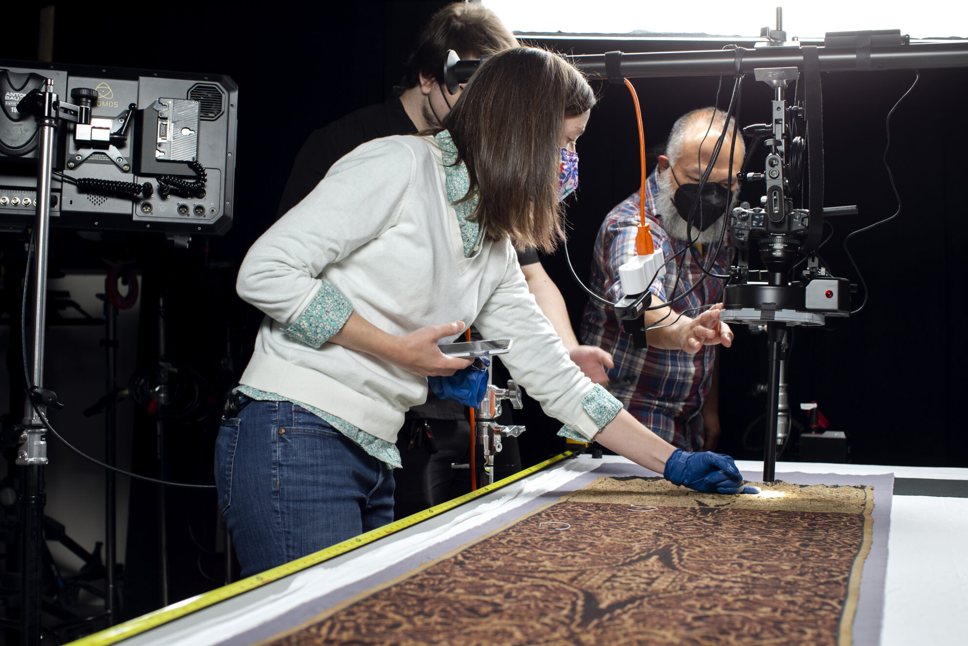 The team works together to prepare an object from the Gregg for image capture