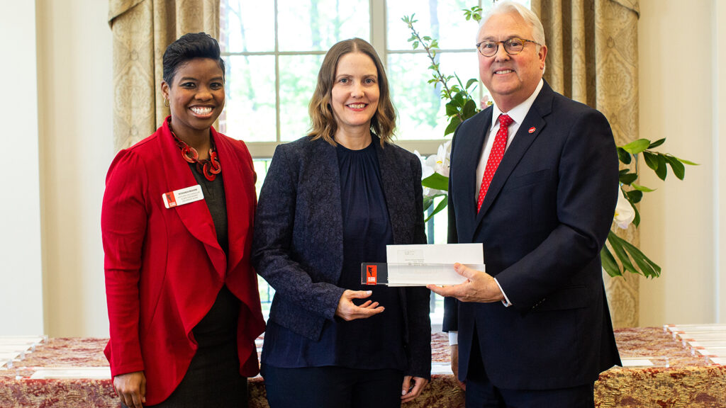Autumn Belk in between Chancellor Randy Woodson and Reshunda Mahone, vice chancellor for alumni engagement and annual giving