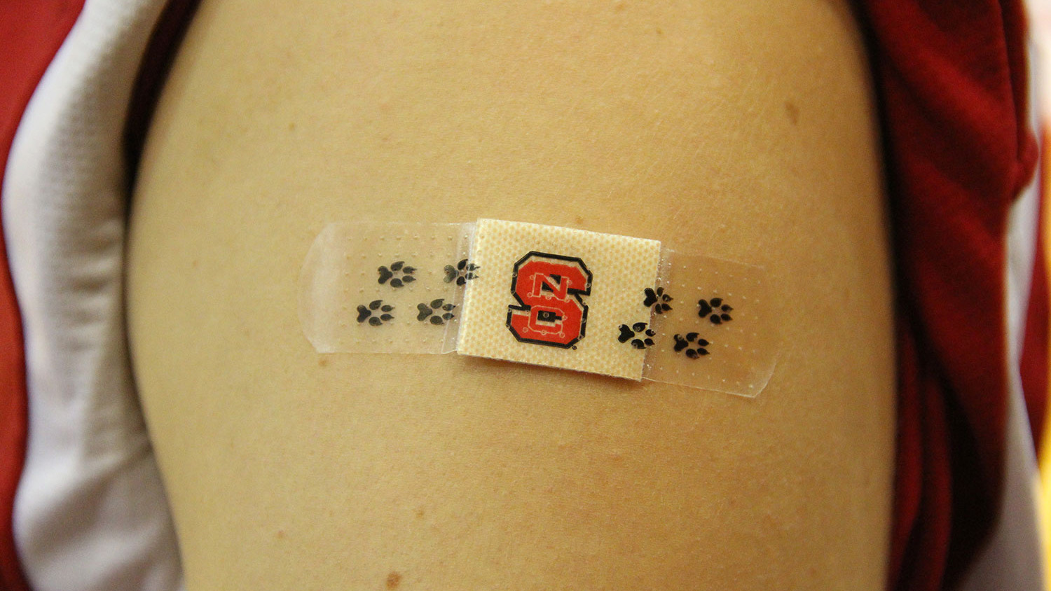 An NC State student sports a Wolfpack bandaid on their arm after receiving a flu shot.