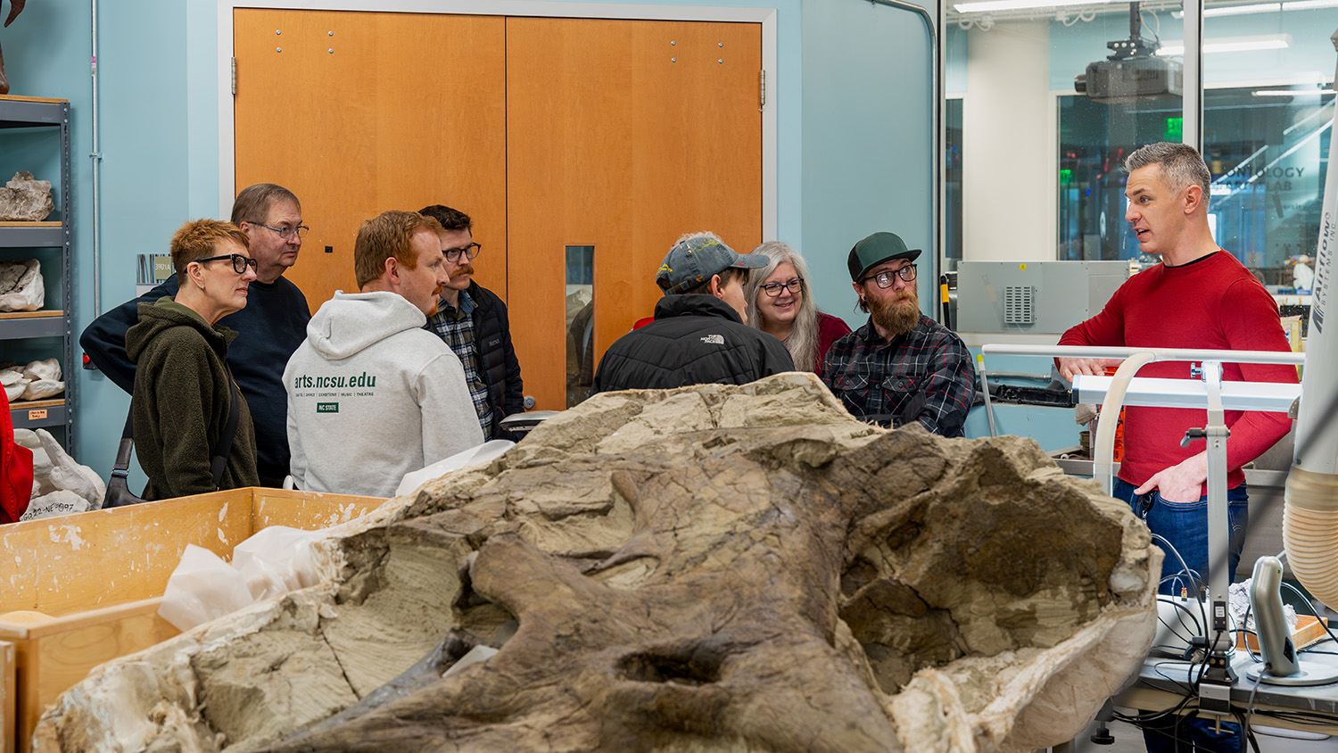 Staff from The Crafts Center take a tour of the North Carolina Museum of Natural Science's dinosaur lab.