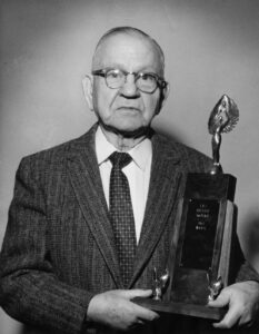 John F. Miller holding a trophy