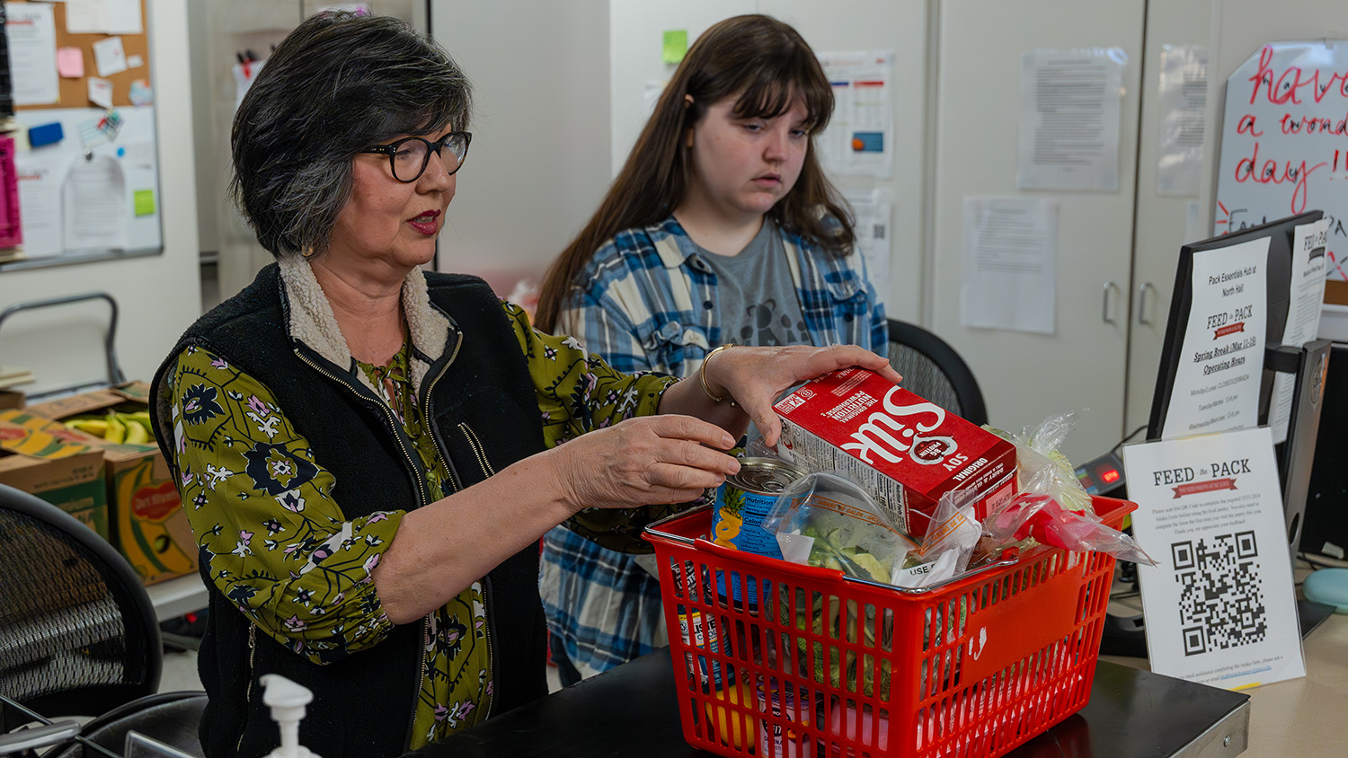 Gladys Deaton, left, one of Pack Essentials' biggest supporters, stocks the Feed the Pack Food Pantry.