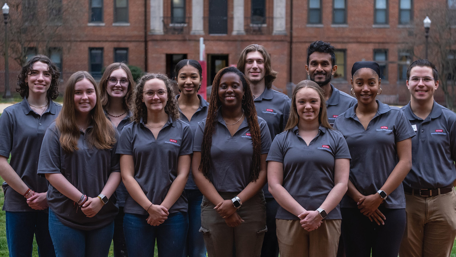 A group of University Honors Program Ambassadors smile for the camera in the Honors Quad.