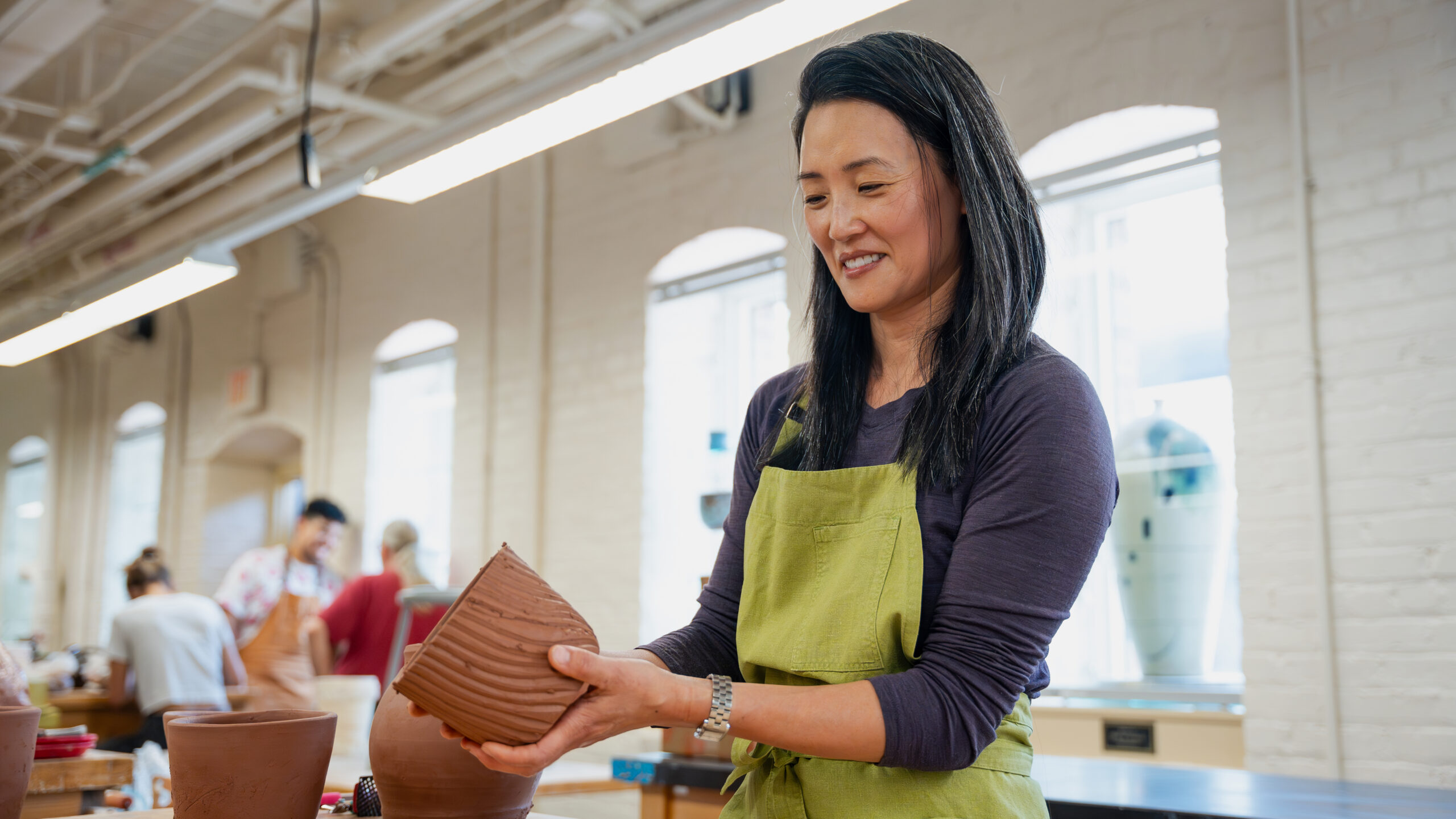 Jane Kim adds detail to a pot in NC State's Clay Studio.