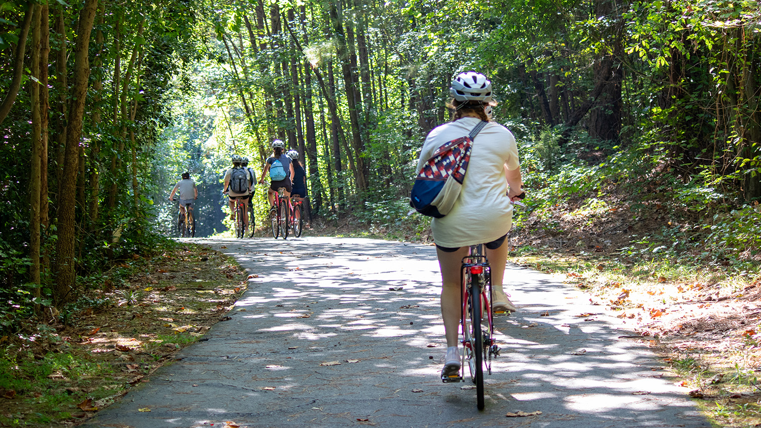 A student rides a bike down a trail.