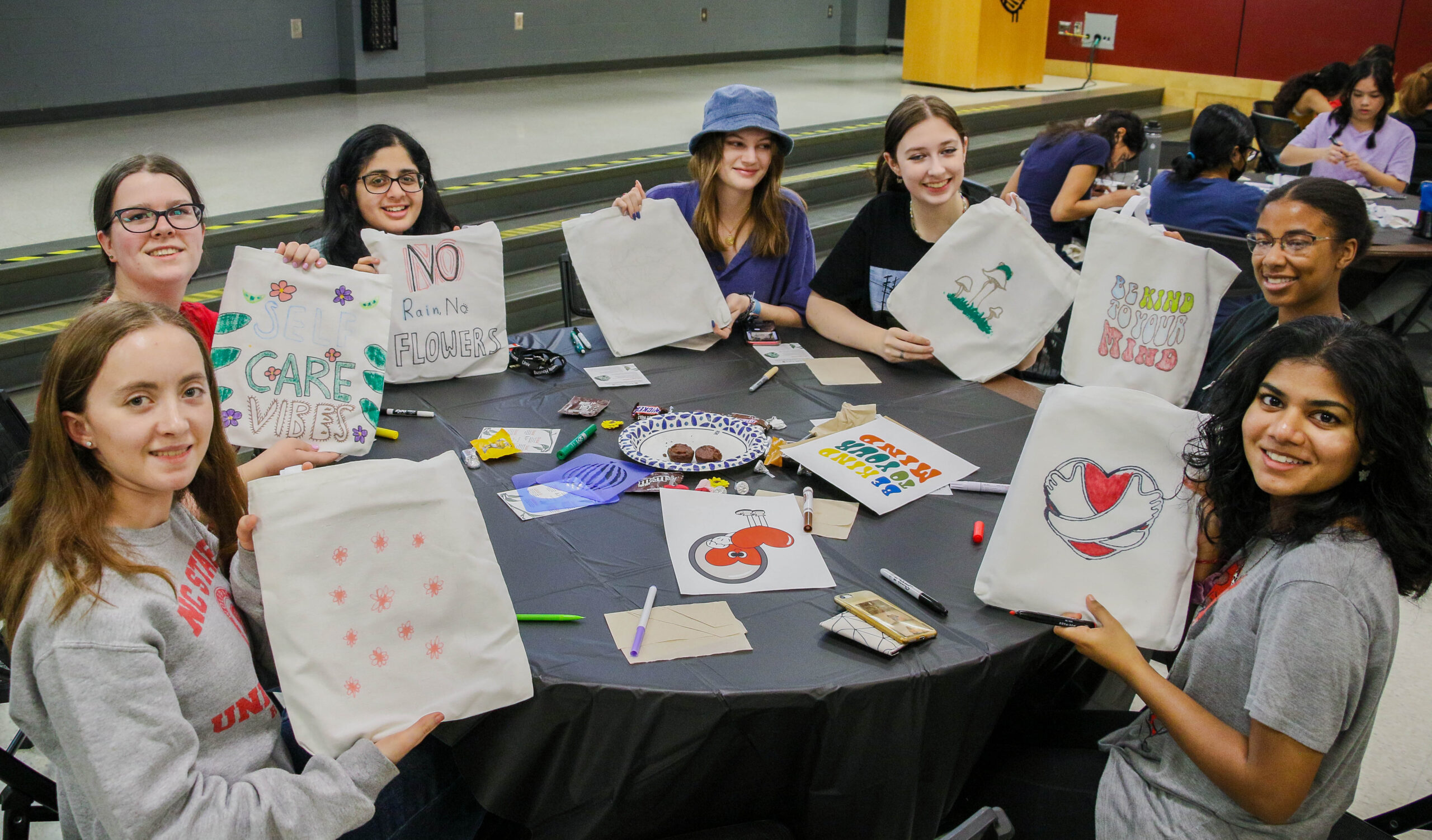 students holding up artwork at a Howl and Chill event