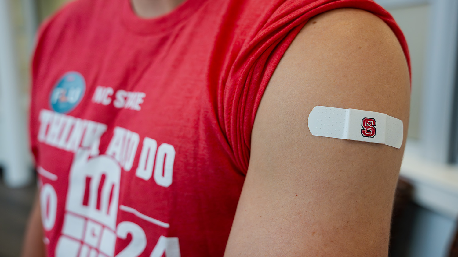 An NC State flu clinic patron proudly sports a Wolfpack band-aid.