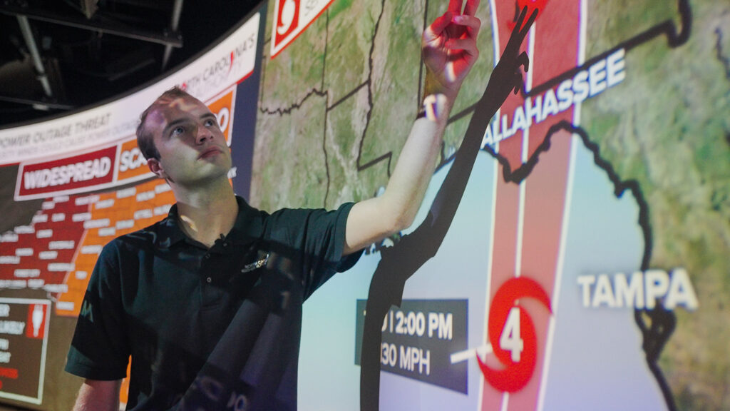 Ethan Clark demonstrates Hurricane Helene's path. 