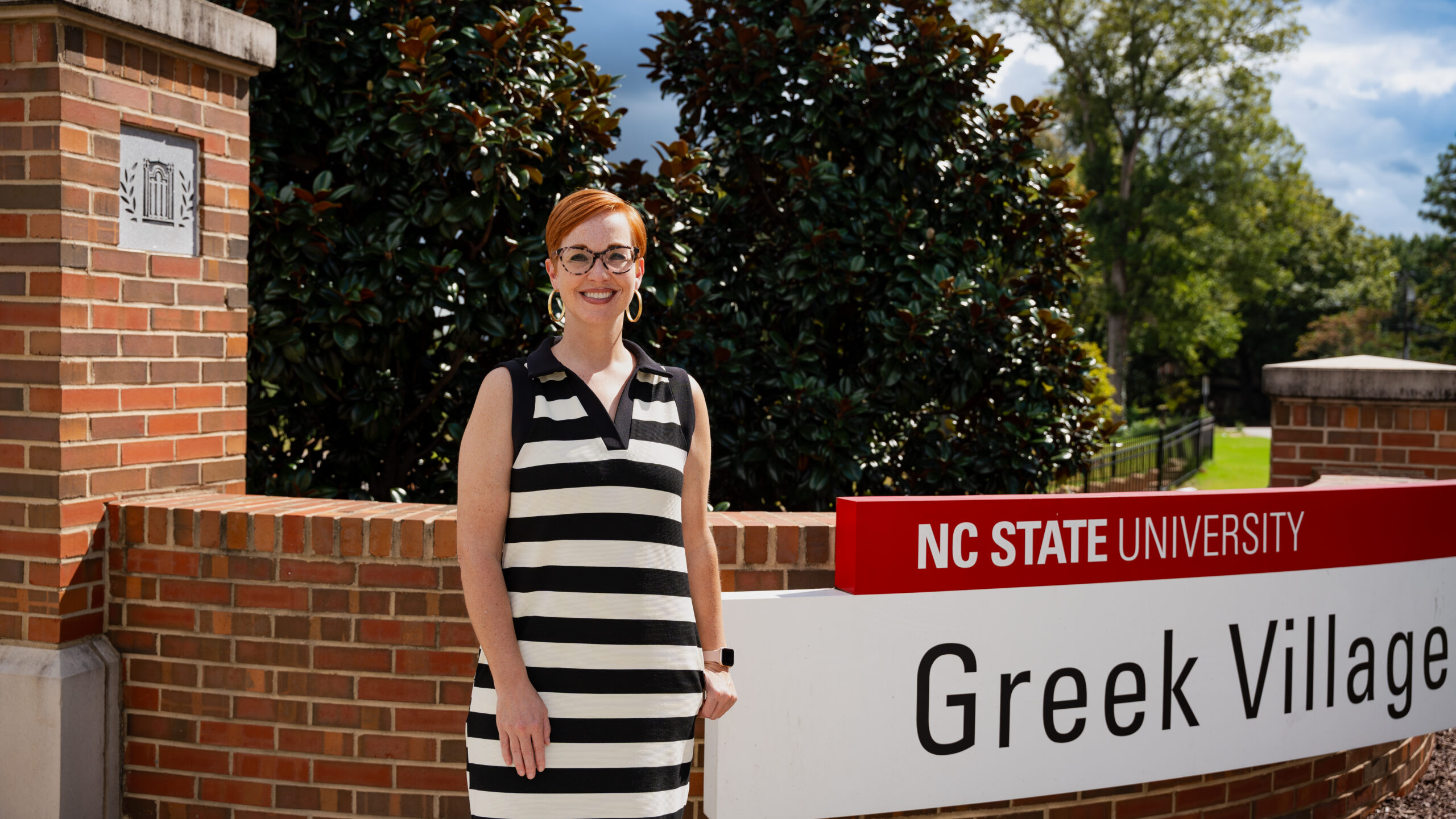 Shelly Brown Dobek in front of the Greek Village entrance sign.