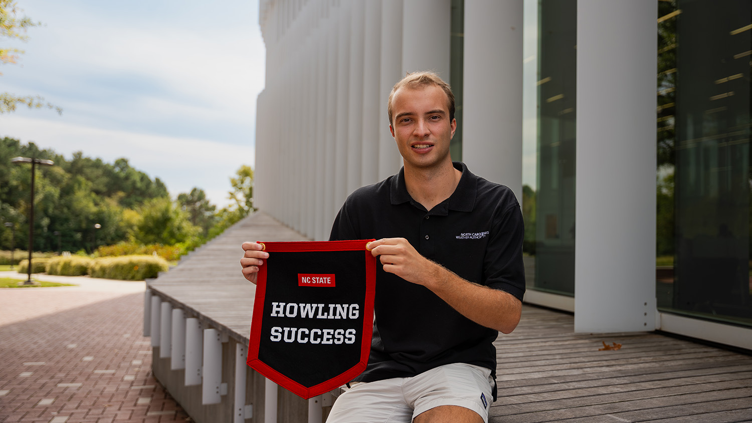 Ethan Clark displays his Howling Success banner outside Hunt Library.