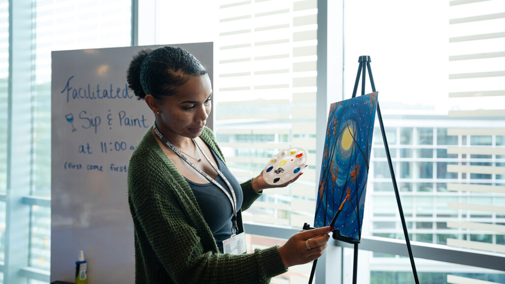 A student paints at the Electoral Wellness Fair in Talley. 