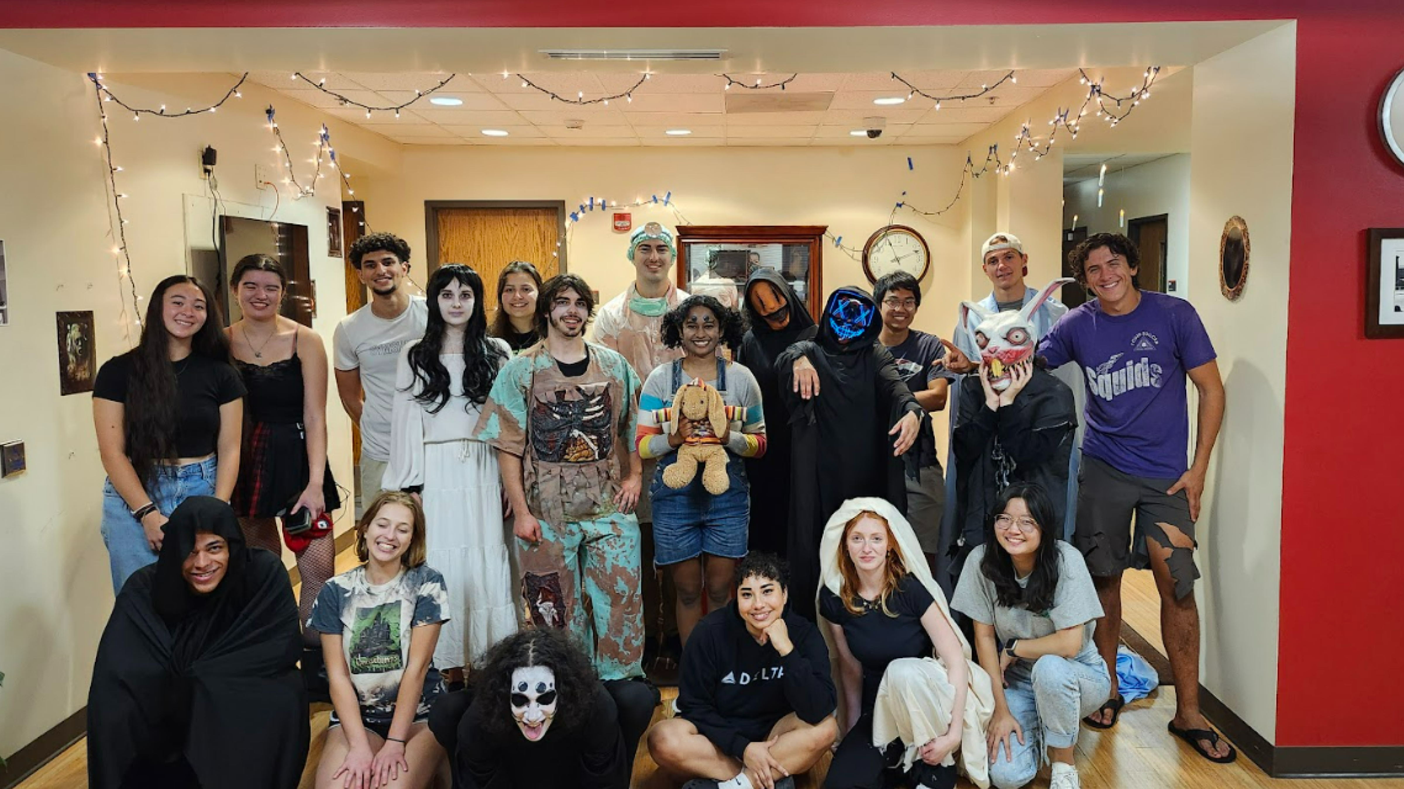 Several students standing in a group in various costumes in preparation for the haunted house event.