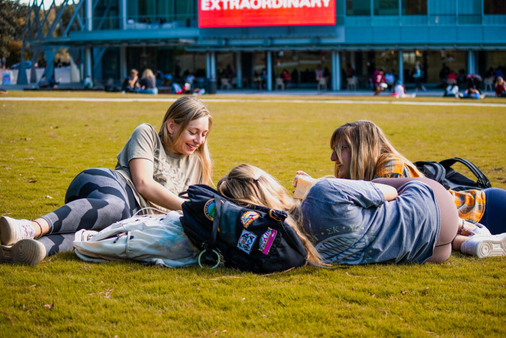 Students relax on the sunshine on Stafford Commons.