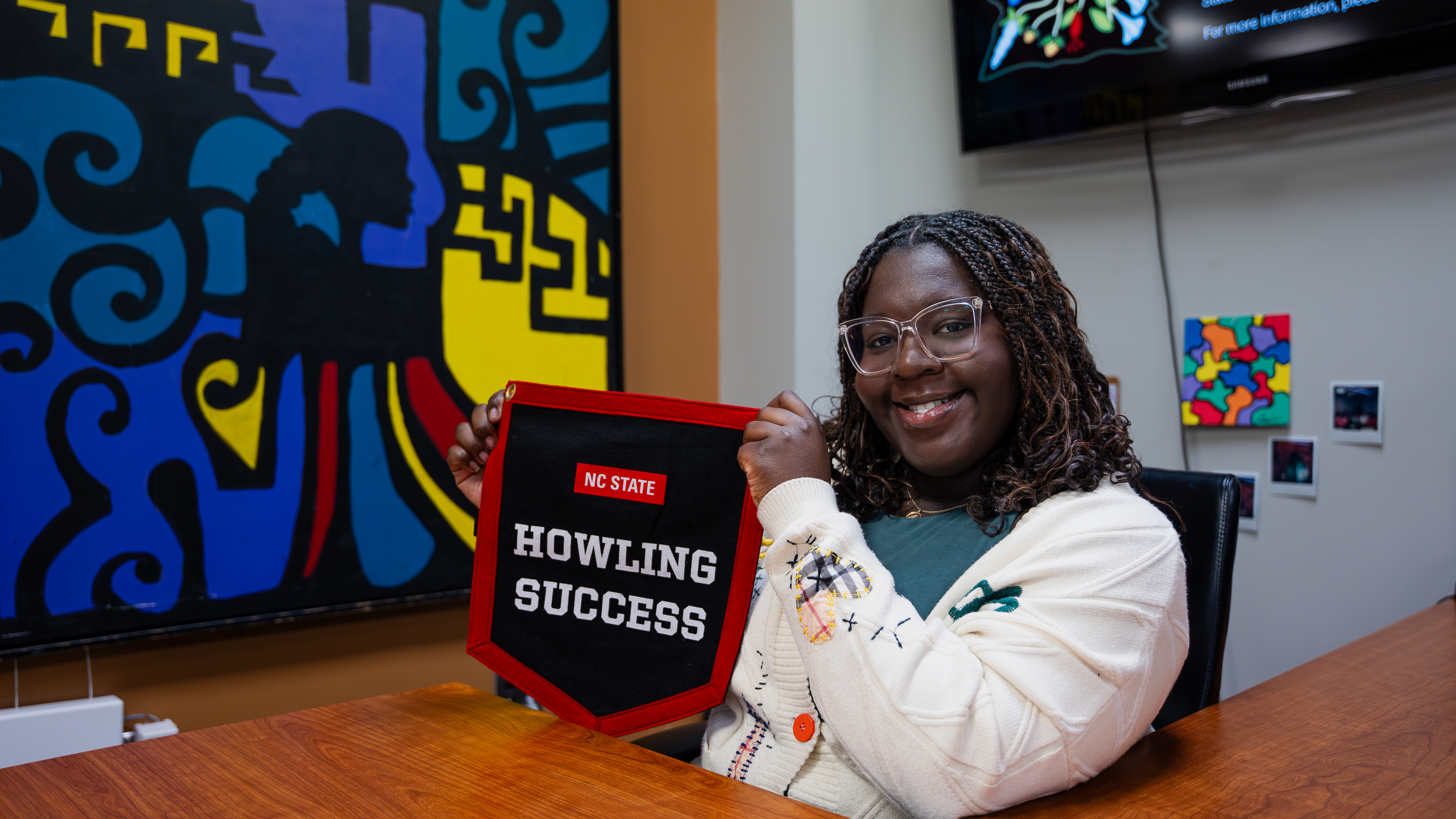 Danielle Moody proudly displays her Howling Success banner in the African American cultural center.