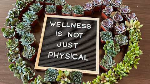 A heart-shaped wreath that displays the message "Wellness Is Not Just Physical."
