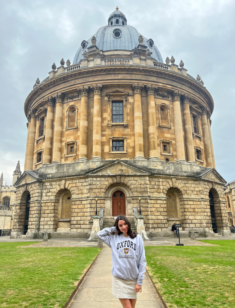 Hoyos poses in front of an iconic Oxford landmark, the Radcliffe Camera building, a working library and part of the central Bodleian Library complex.