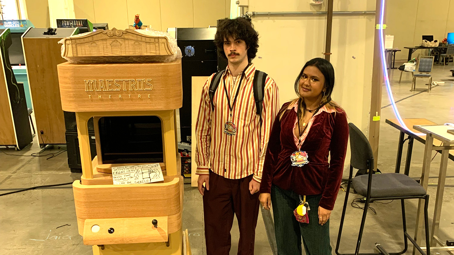 Students display their arcade machine research projects.