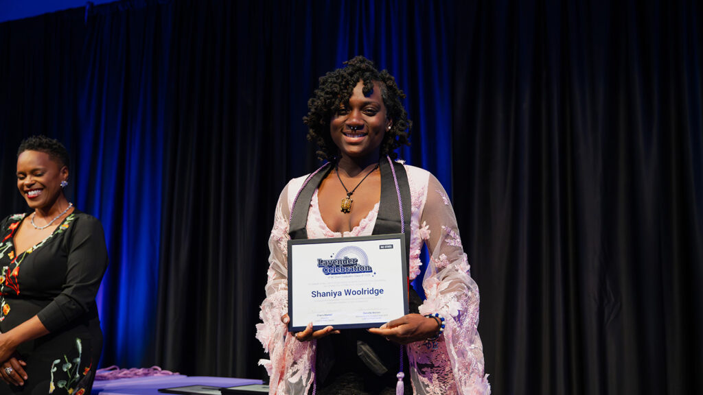 Shaniya Woolridge holds up their Lavender Celebration certificate. 
