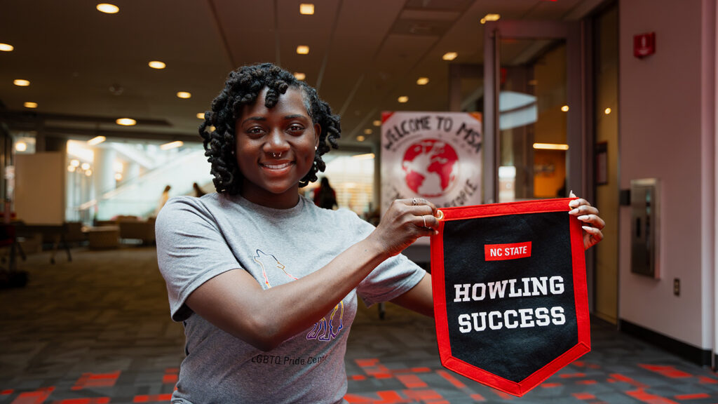 Shaniya Woolridge displays their Howling Success banner outside Multicultural Student Affairs in Talley Student Union. 