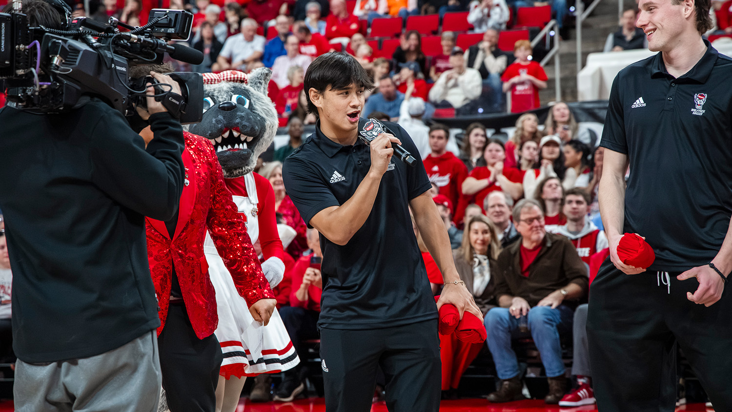 Caden Tolentino speaks during an NC State men's basketball game at Lenovo Center.
