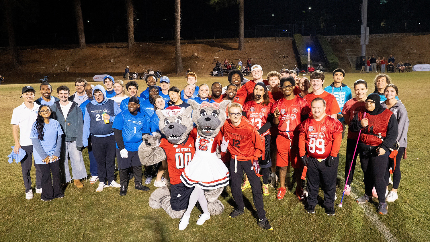 Unified Sports participants gather for a photo with Mr. and Ms. Wuf after a rivalry series flag football game.