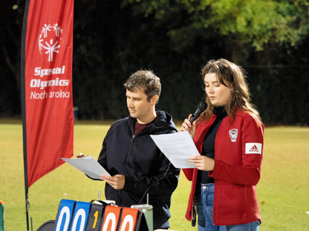 Charlie Buss (right) speaks at a Unified Sports event.